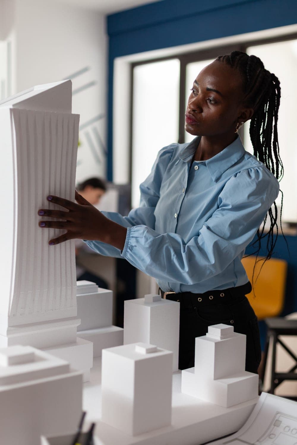 Woman architect refining a building model in studio